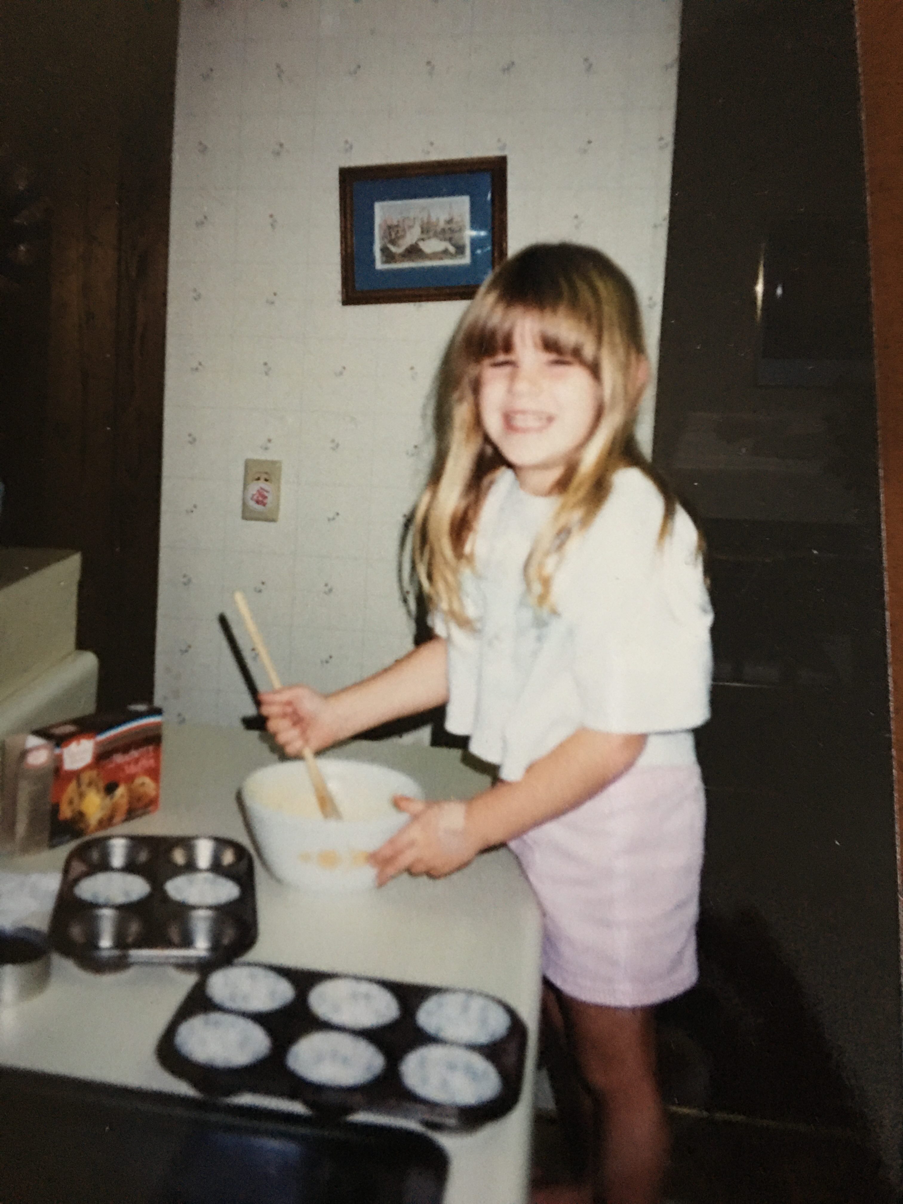 Ashley as a child baking cupcakes in her home kitchen.